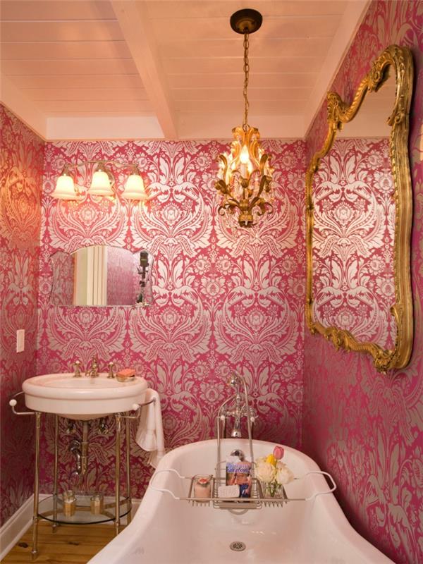 biela vaňa, baroková ružová tapeta, barokové rámové zrkadlo a závesné svetlo, okrúhle umývadlo; malé ozdobné zrkadlo