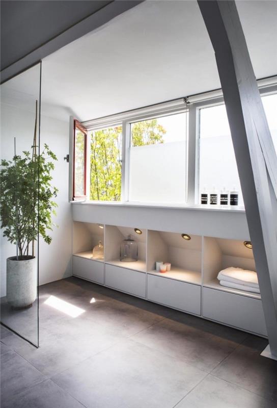ett modernt designat badrum med sluttande skåp integrerat i basen som erbjuder extra lagringsutrymme