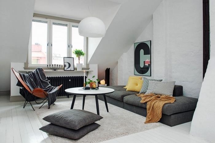 ett vindsvåning i modern skandinavisk design med en soffa på marknivå placerad under sluttningen