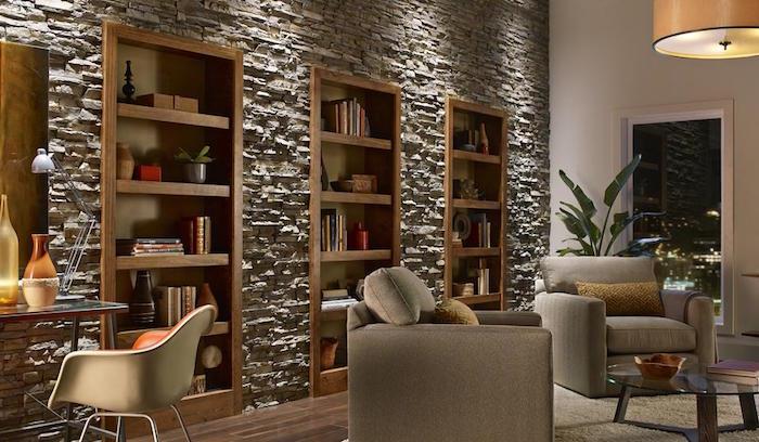 obývacia stena pokrytá doskami zo sivých obkladových kameňov obklopujúcich drevené police a knižnice