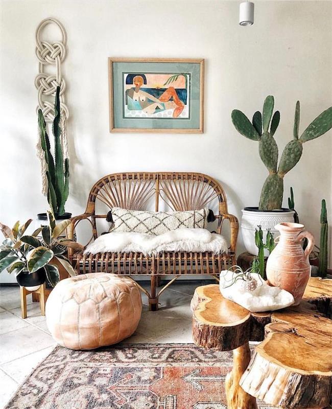 غرفة معيشة أنيقة بوهيمية مع أريكة من القش ، سجادة شرقية ، طاولة قهوة ، جدران بيضاء من خشب الصبار بوعاء