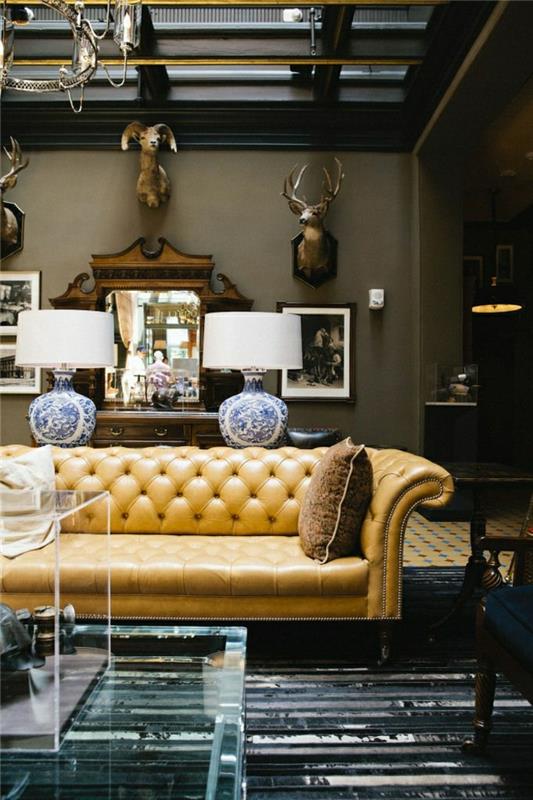 obývačka-kožená sedačka-béžová-kožená-stena-dekoracia-béžovo-šedá-steny-zrkadlo-transparentná tabuľka