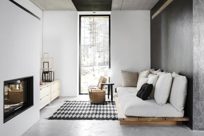 priestorovo úsporné usporiadanie malej elegantnej čiernobielej obývačky vybavenej elegantným dizajnom paletovej sedačky