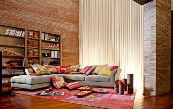 salon-roche-bobois-tehlové steny-sivá-rohová sedačka-a-ružový koberec