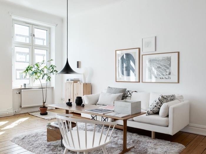 čistý biely škandinávsky model obývačky, sivý koberec, biela sedačka, sivé, biele a čierne vankúše, stôl z masívu, biela stolička, škandinávsky koberec, svetlé parkety