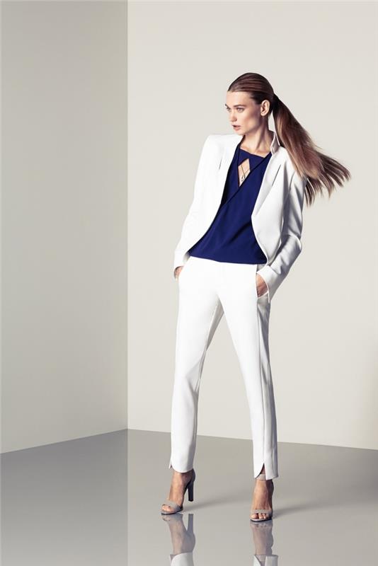 kvinnaskjortsmodell i mörkblått, vit vit blazer med smala vita byxor, exempelvis dambyxor med fickor