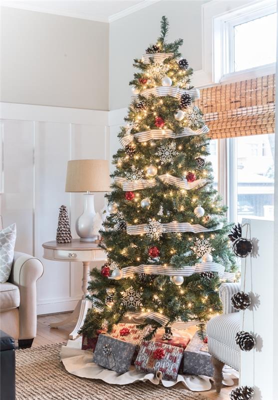 Vianočný stromček zdobený prírodnou tematikou, žlté vianočné svetlá, ozdoby, vločky, biela a čierna stuha