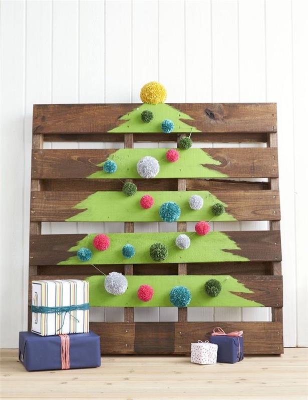 vyrobte vianočný stromček z drevenej palety s kresbou zeleného stromčeka ozdobeného farebnými pomponmi, darčekov rozmiestnených okolo