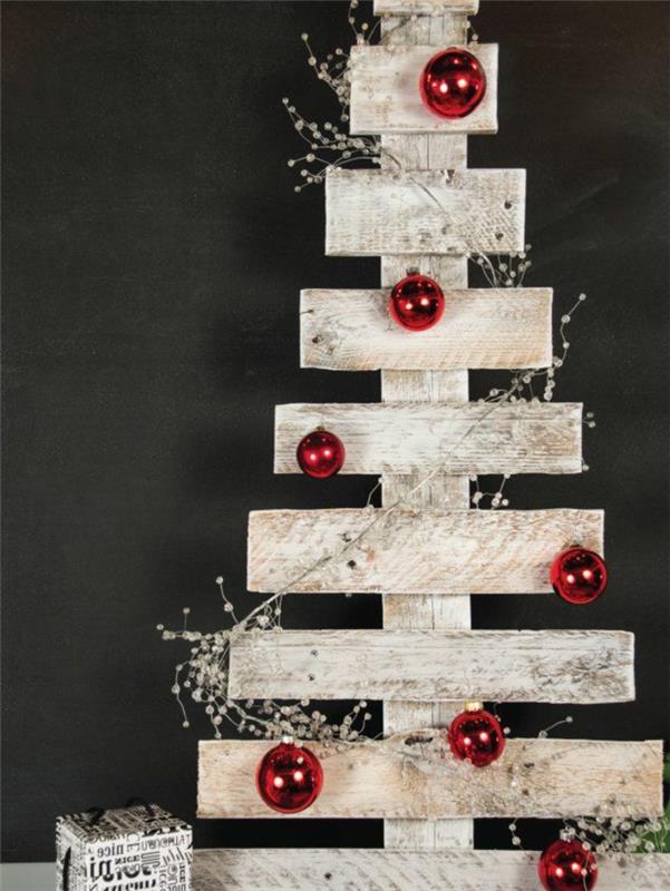 jemná výzdoba v škandinávskom štýle, paleta premenená na vianočný stromček, červené vianočné gule a suché biele kvety