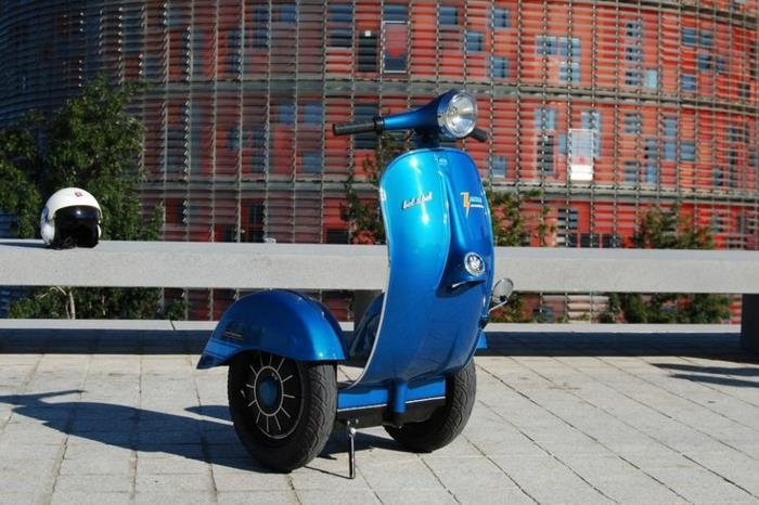 skúter-motor-ročník-vespa-primavera-čisté-mesto-s-dvoma-červenými-elektrickými