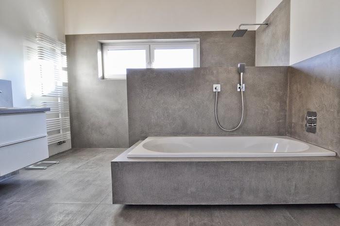 sivý voskovaný betón pre sprchovú stenu a rám vane na dlažbe s cementovým efektom