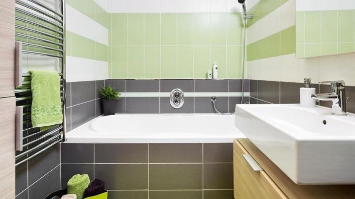 modern inredning i neutrala och gröna färger, vitt och grönt kakelmönster, exempelvis badkar i litet badrum