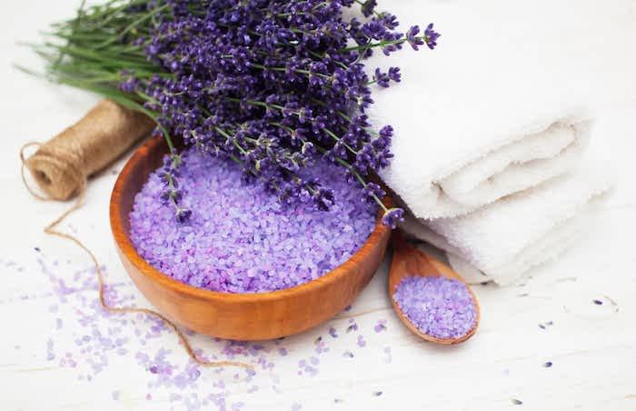 lavendel badsalter med en bukett lavendel bredvid hemlagat lavendelvatten