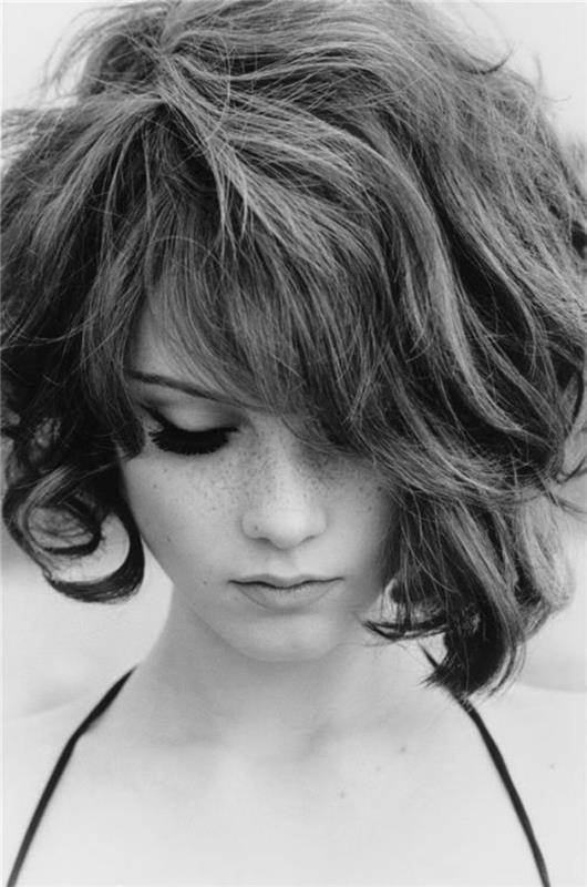 zrážky pre ženy, čiernobiely obraz mladej ženy, krátke vlasy v štýle 60. rokov, pri pohľade dole, bočné ofiny a falošné riasy