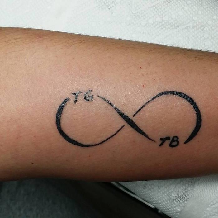 znak nekonečna jednoduché tetovanie na ruke s iniciálami