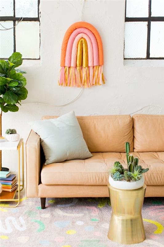 regnbågens väggdekoration i pastellfärger, ljusorange soffa, stor blomkruka, grå kudde, sidobord