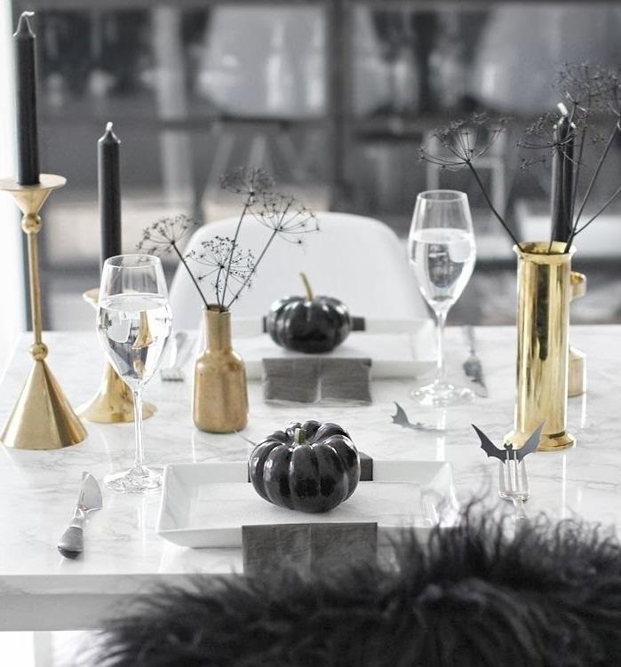 Hallwoeen bordsdekoration i svart och vitt, marmorbord med guldljusstake