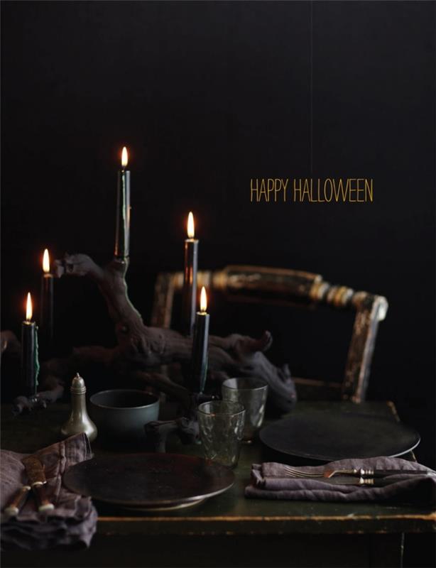 halloweenmåltid, idé hur man ordnar halloweenbordet, svart bord med åldrad trästol och svarta ljus