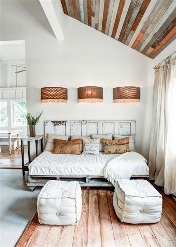 Myšlienka renovácie interiéru, elegantná vidiecka dekorácia spálne s dreveným nábytkom a vlastnou paletovou posteľou