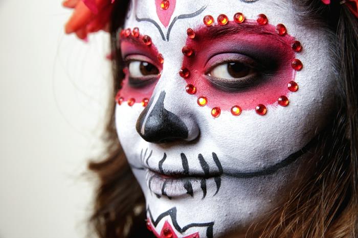 mexický halloween make -up, oranžové trblietky okolo červených kruhov, čierny nos, kvet na brade