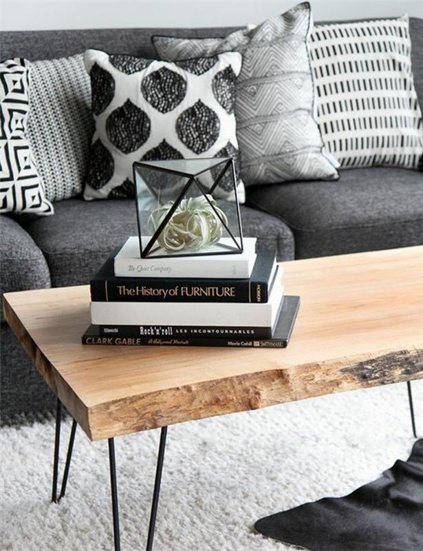 Soggiorno con tavolino di legno, divano di colore grigio, decorazione con libri