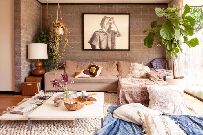 bohémsky elegantný dekor obývačky so sivými tehlovými stenami s drevenými podlahami, rohový model pohovky potiahnutý berberskými vankúšmi