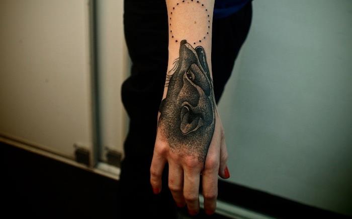 vlčie tetovanie na ženu, červená manikúra a tetovanie na ruku s dizajnom vlka a mesiaca