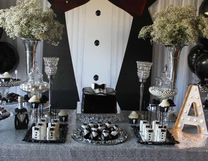exempel på en 30 -årig mans födelsedagsbord dekorerat i vitt och svart med silverporslin, snygg dekoration för herrkalas