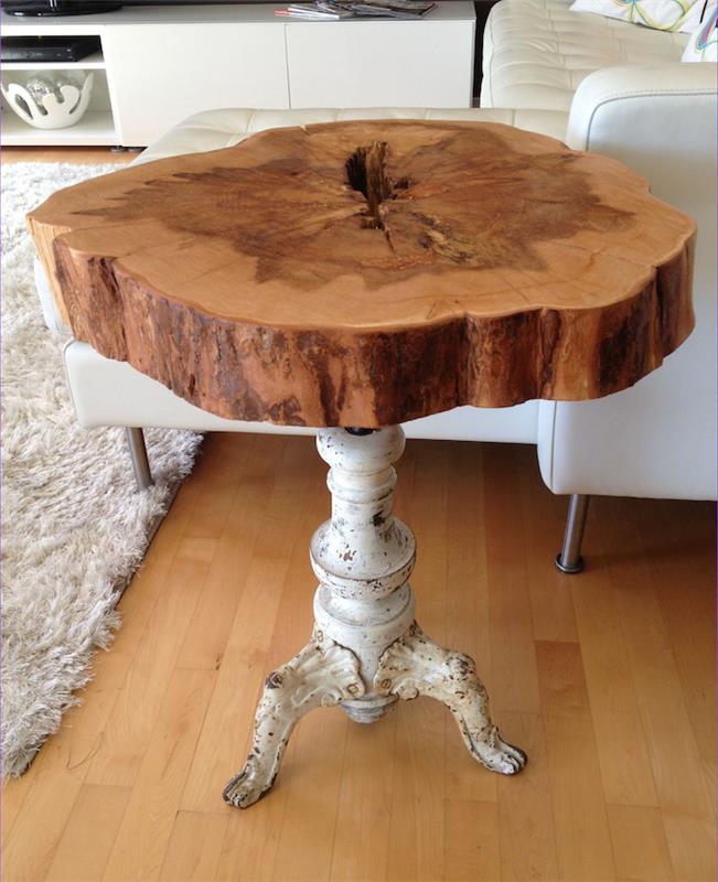 صورة لطاولة قهوة من الخشب الطبيعي الريفي مع ساق معدنية بيضاء عتيقة
