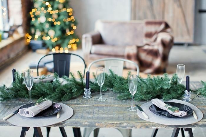 rått träbord rustik inredning minimalistisk stil champagneglas julens mittpunkt svart rund tallrik vit servett