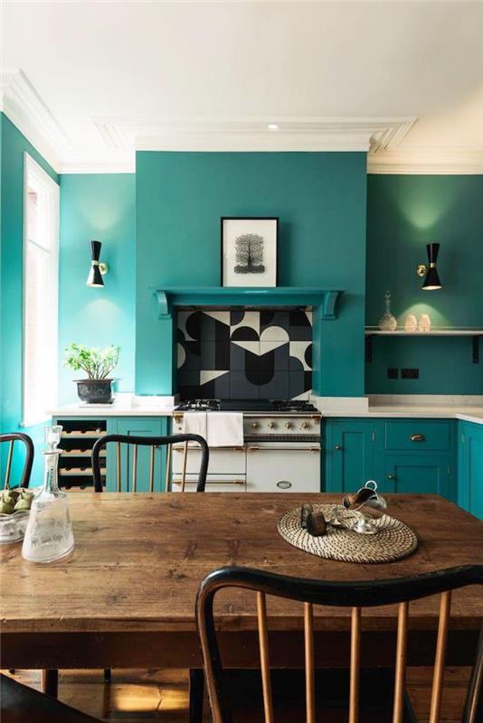 Akvamarínová modrá kuchynská maľba na stenu, drevený jedálenský stôl, pohodlné biele kuchárske stoličky