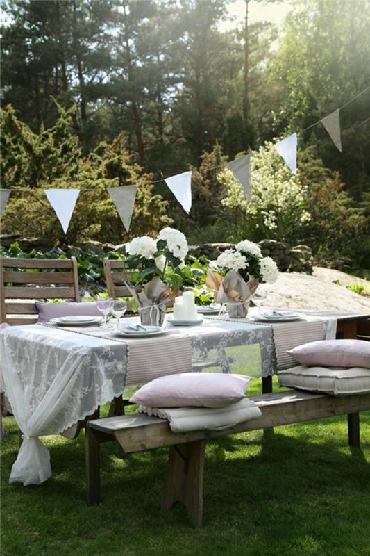picknick-trä-bord-blommor-vit-spets-duk-gräsmatta-trädgård-bord