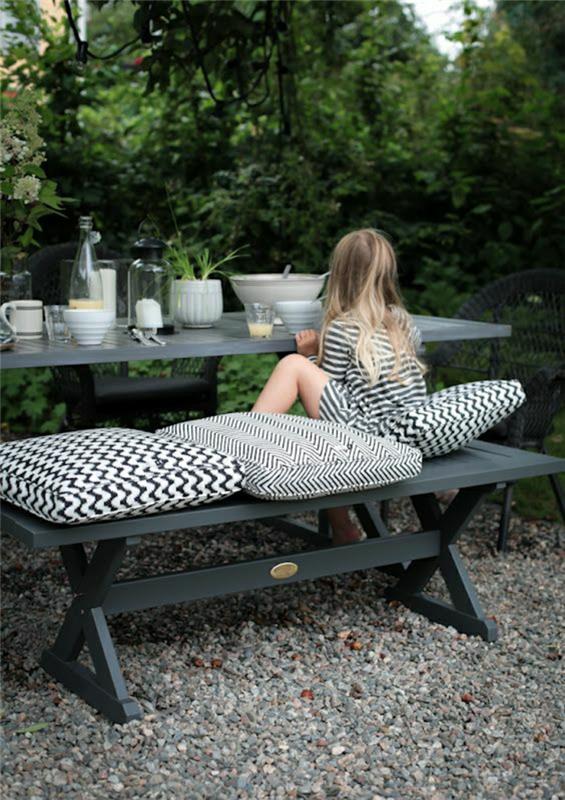 picknick-bord-i-grå-järn-blond-barn-flicka-äta-trädgård-sten-bord