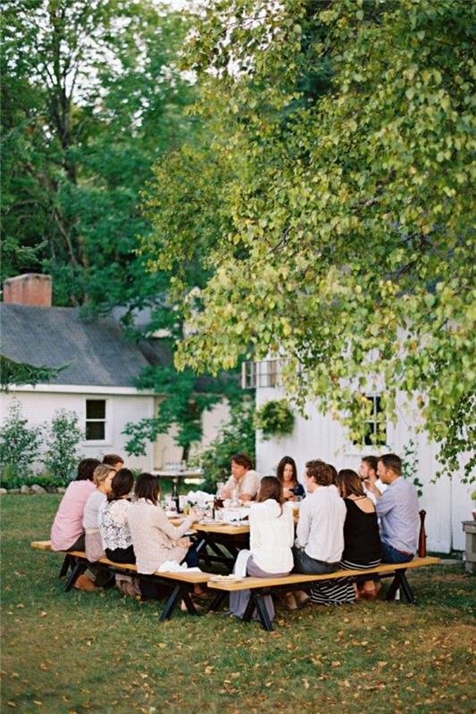picknick-trä-bord-trädgård-gräsmatta-grön-lunch-i-trädgården-folk-gården