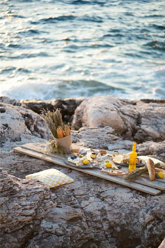 picknick-bord-på-stranden-vacker-utsikt-trä-bord-blommor-på-picknick-bordet