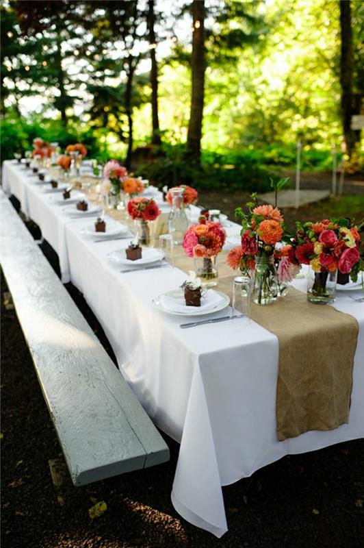 trä-picknick-bord-vit-bordsduk-blommor-på-dessert-bord-löpare