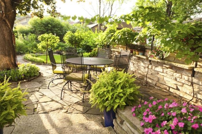 كيف تنشئ حديقتك ، فناء خلفي مع منطقة استراحة مفروشة بأثاث من الحديد وطاولة مستديرة وكراسي