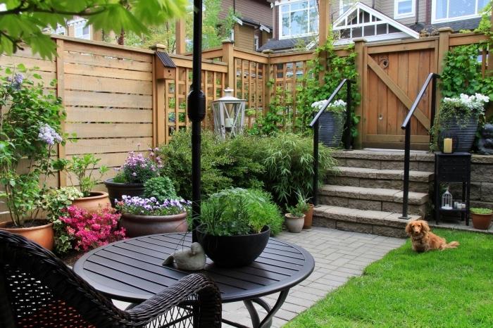 krajinný dvor s dreveným plotom, dekorácia malej záhrady s trávnikom a odpočívadlom zariadená tkanou stoličkou