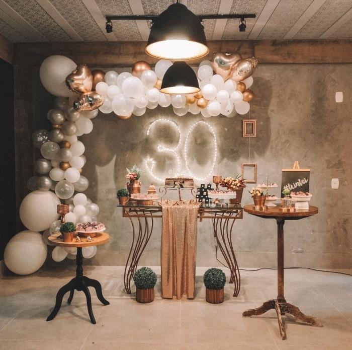 dekoration för en kvinnas 30 -årsfest, rum med betongväggar dekorerade med ballonger i vitt och roséguld för en 30 -årsfest