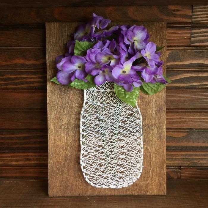 enkelt DIY -mönster med mörk träplanka och vit trådformad skapelse med konstgjorda blommor