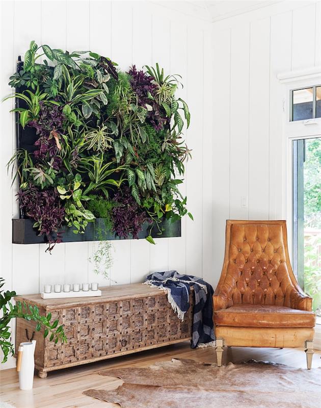 vnútorná zelená stena tvorená zelenými rastlinami, kožená stolička, kožený koberec, biele steny, svetlé parkety, exotická výzdoba obývačky