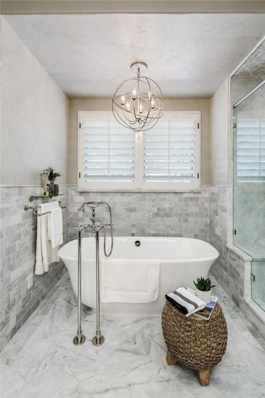 modern badrumsinredning med tak och klinkergolv i marmordesign, liten fristående badkarmodell