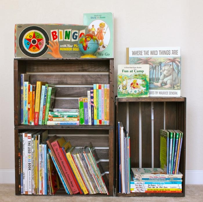 príklad malej knižnice pre deti vyrobenej z detskej izby vyrobenej z brúsených drevených debien a prelakovanej farbou na tmavý drevo