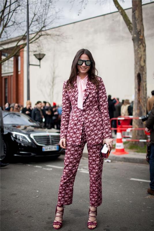 chic kvinnas outfit i en retro chic kostym i ett grafiskt tryck i rosa och vinrött i samband med en rosa skjorta med en rosettkrage