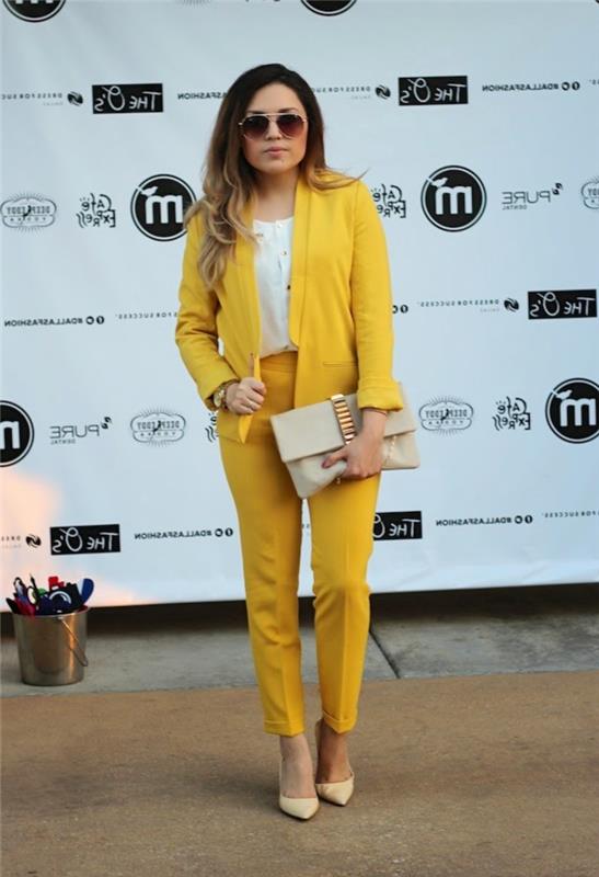 chic och feminin vision i en elegant kvinnas byxdress i gul färg kombinerat med accessoarer i neutrala toner