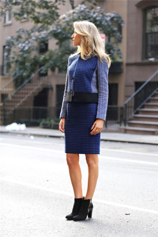 utseendet på en elegant arbetande tjej i en kvinnas kjoldräkt i marinblå tweed och en snygg sida med ett par läderstövlar