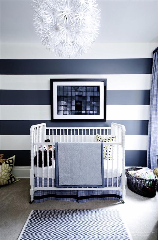 moderné usporiadanie detskej izby s pruhovanými dizajnovými tapetami a lustrom s kvetinovým vzorom pre monochromatický dekor v bielej a tmavomodrej farbe