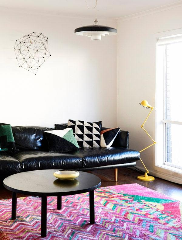 mångfärgad-matta-och-svart-läder-soffa