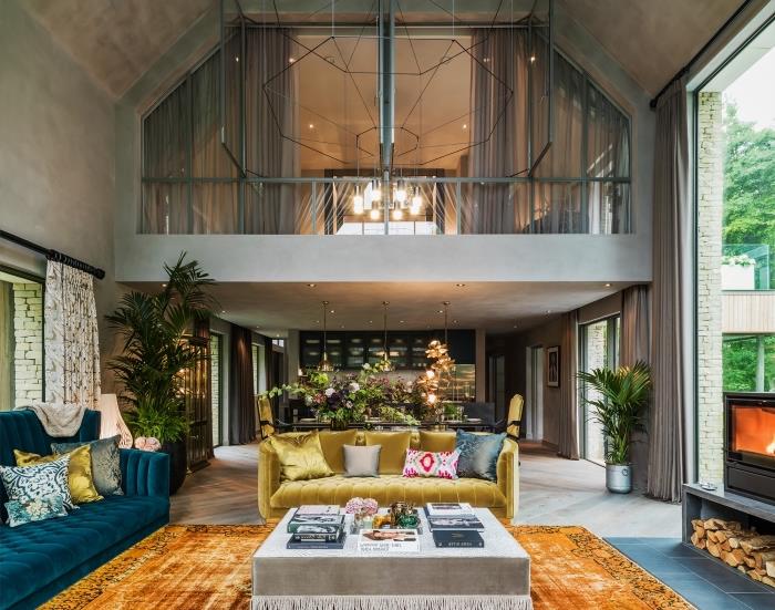 moderný interiérový dizajn v medziposchodí s cementovými stenami a sivými drevenými podlahami, eklektickým dekorom obývačky so zamatovým nábytkom