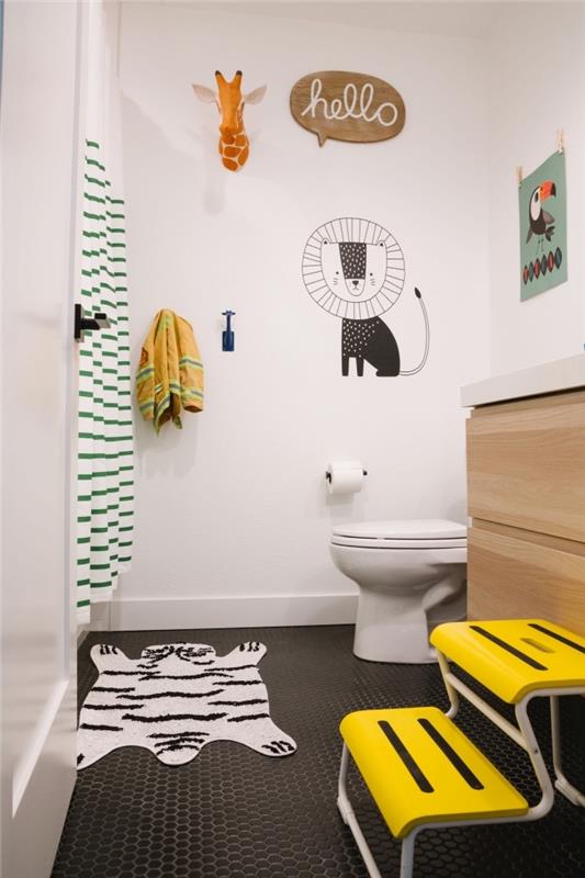 badrum i vitt och trä med svart klinkergolv, liten badrumsdekoration för barn med djurmotiv